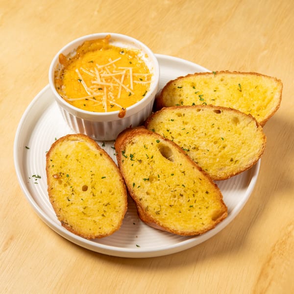 Granchio's cheesy seafood dip with shredded cheese and herbs, served with four slices of garlic bread.