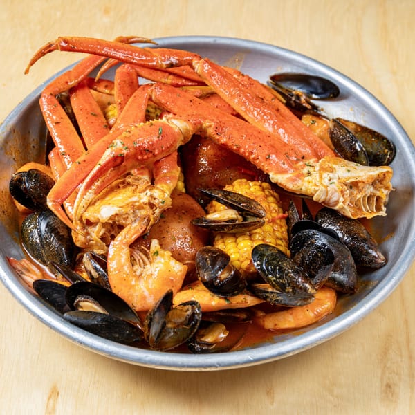 Granchio's seafood boil with crab legs, mussels, shrimp, corn, and potatoes in a metal bowl.
